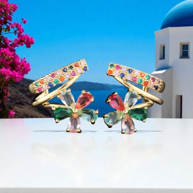 Pendientes de aro dorados con diseño floral multicolor sobre fondo turquesa