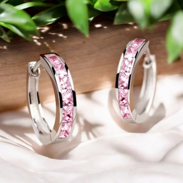 Pendientes aro chapados en oro de 18k con circonitas rosa sobre fondo blanco