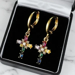 Modelo luciendo pendientes de cruz multicolor chapados en oro de 18k