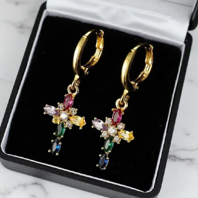 Modelo luciendo pendientes de cruz multicolor chapados en oro de 18k