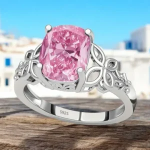 Anillo de plata 925 acabado rosa con circonita central sobre fondo floral.
